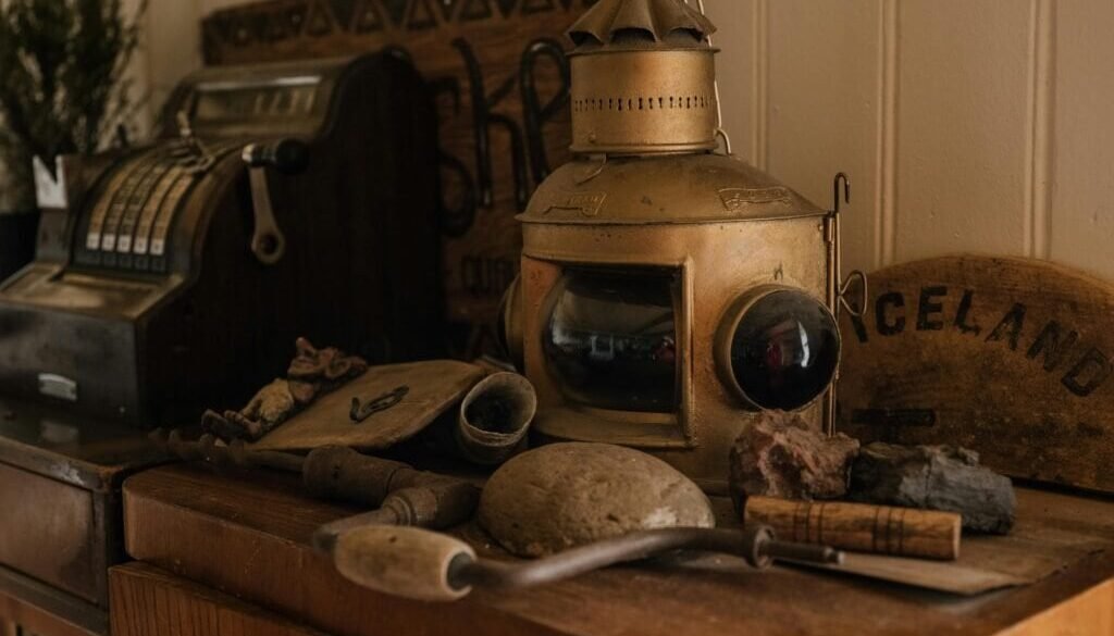 A collection of vintage items including a cash register and a lantern on a wooden cabinet.