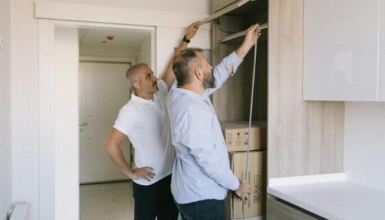 pexels-photo-8978598-8978598 Two men measuring a modern kitchen cabinet for a renovation project in an apartment.
